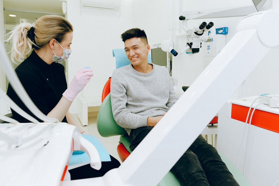 Dentist chatting with a smiling patient in a modern surgery